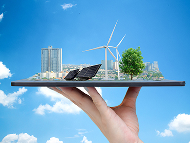 assistenza-impianti-da-fonti-rinnovabili-trentino Mano regge un tablet con immagine di città e energie rinnovabili